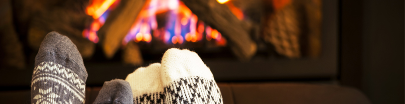 Woolly socks and toes warming by a log fire